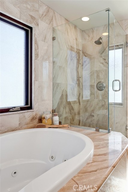 Master bathroom includes an updated luxurious soaking tub and separate walk-in shower with glass enclosure.