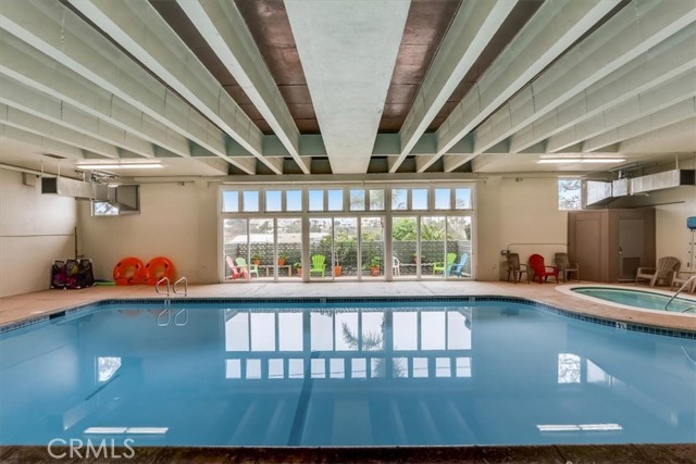 Glistening indoor heated pool for your use in the community with spa in the background!