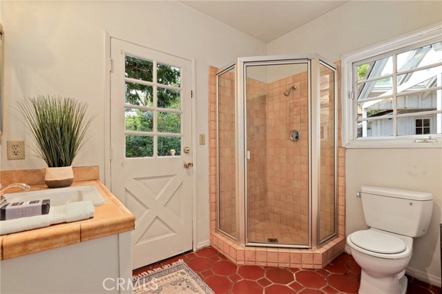 Bathroom that feeds downstairs bedroom off to the left of the home with direct access to the pool deck for folks to shower off afterwards!