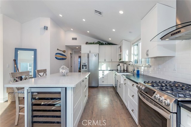 Chef's kitchen includes six-burner stove and wine fridge.