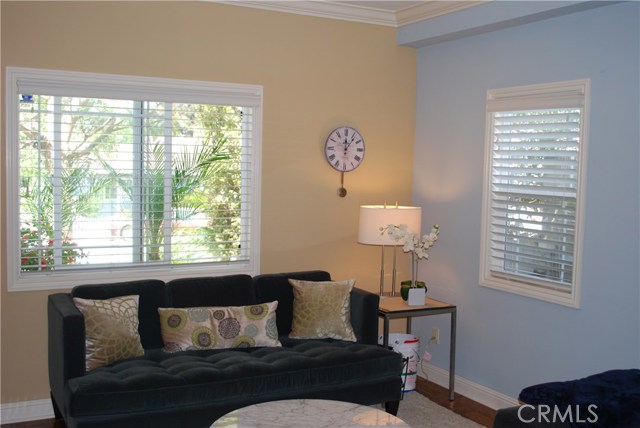 Bright Living Room...distressed hardwood floors, romantic cozy fireplace and crown molding.