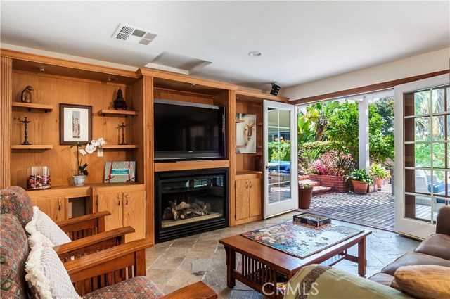 Inviting Family Room has fireplace + French doors leading to outdoor living space.