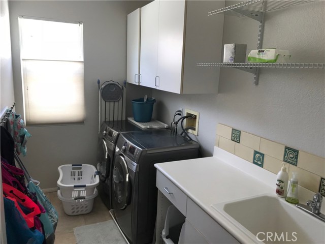 Upstairs Laundry room with sink and lots of storage