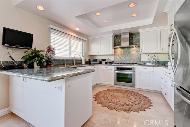 Travertine floors and expansive 'Costa Smeralda' granite countertops make this a chef's dream kitchen.