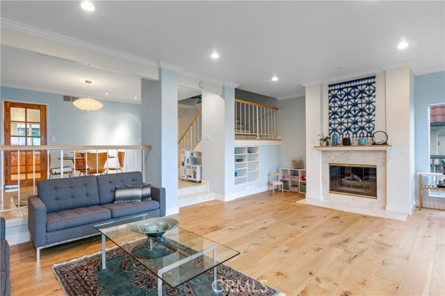 Living area is light and bright with abundant natural light from wall of windows + recessed lighting.
