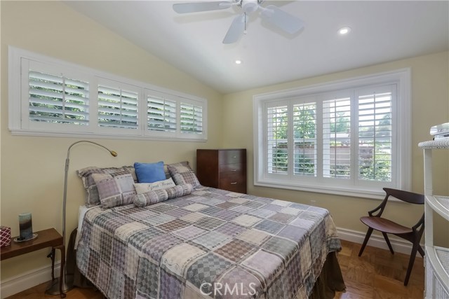 Large guest bedroom, plantation shutters, hardwood floors.