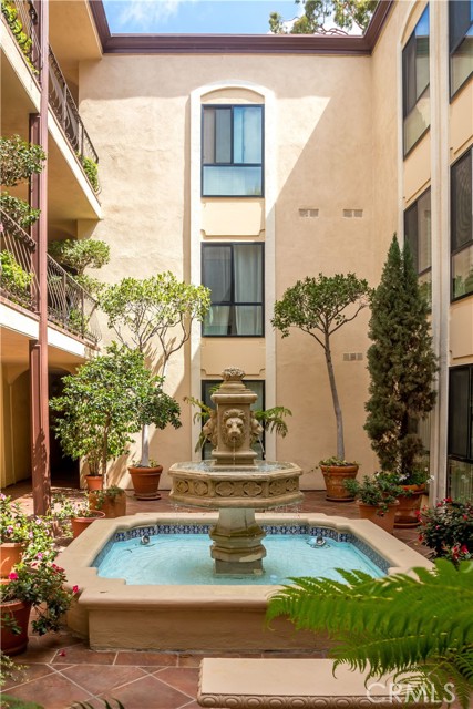 Beautiful courtyard area with tranquil fountain and abundant lush plants.