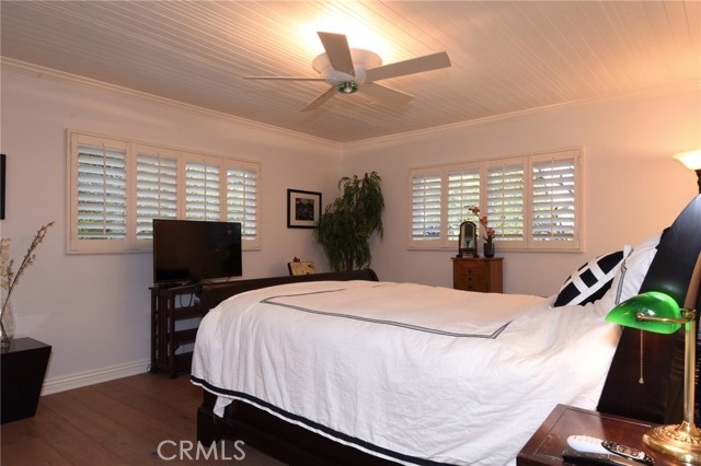 Romantic master bedroom has gorgeous wood flooring, plantation shutters (like the rest of the house!), and ocean peak views.  Walk in closet, too!