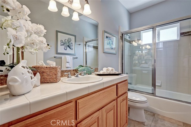 Guest bathroom with combo shower/tub and travertine floors.