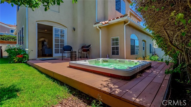 Built in spa and deck.The grassy backyard has mature fruit trees.Behind are the double french doors that lead into the family room with the bar.