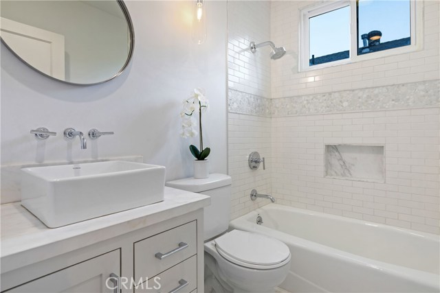 The hallway bathroom has been adorned with Walker Zanger Studio Moderne Stone: Calacatta Paramount Mosaic,
Walker Zanger Field Subway tile, Bath Fittings: Kohler Purist, Calacatta stone tile flooring, Lutron dimmer light switches.