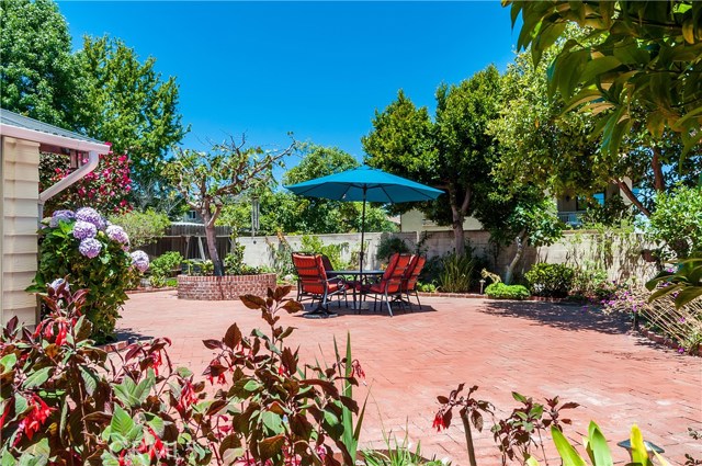 Large sunny backyard with easy care brick patio. Border flower beds and mature trees provide green shade. This lot is one of the highest points in the neighborhood.