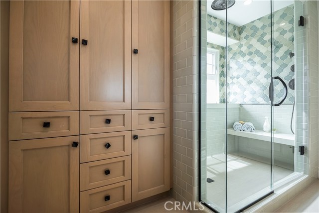 Master bathroom with storage cabinets; walk-in shower with bench seating