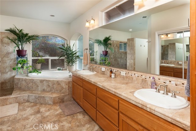 Master bathroom with double sinks, jetted tub, tile floors, walk-in closet.