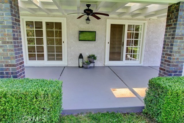 Backyard patio with flat screen tv and ceiling fan