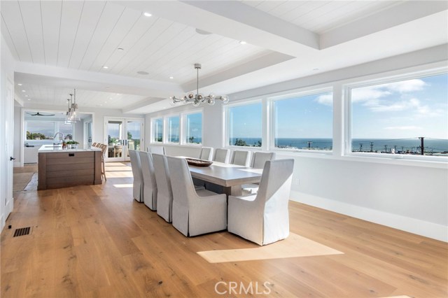 Dining Room through the Kitchen toward the Ocean View Deck with built-in barbecue, ceiling heaters and large sliding doors to bring the outside into the adjacent Family Room.