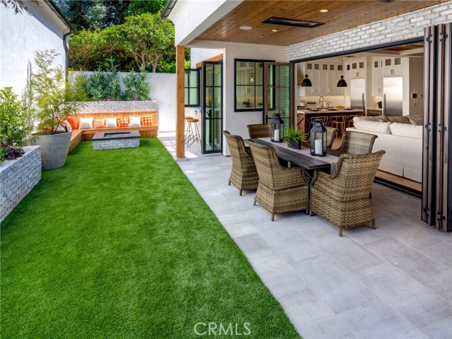 Private backyard, fire pit with seating, low maintenance artificial turf, covered patio with built-in heaters, sandblasted marble floor tiling, LaCantina door systems for the perfect indoor/outdoor experience, surround sound.