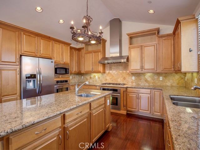 Another view of kitchen with built-in appliances including range/oven with hood, convection oven, microwave, and dishwasher.  Freestanding refrigerator is included in sale!