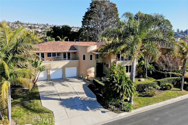 Front view with large driveway and multiple garages