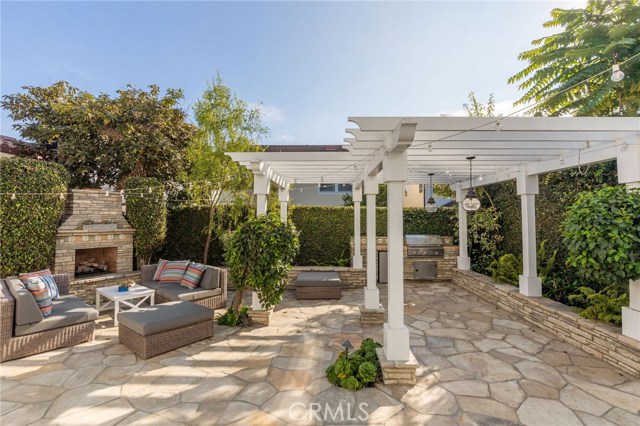 Beautifully Hardscaped South Facing Backyard with Fireplace, BBQ/Grill Center, Pergola and Service Bar