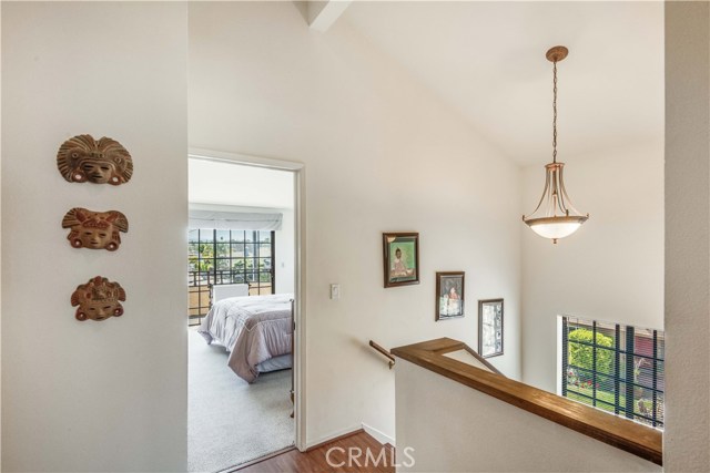 Upstairs hallway has very high vaulted, open-beam ceilings, and wood floors. Looking toward master bedroom entrance.