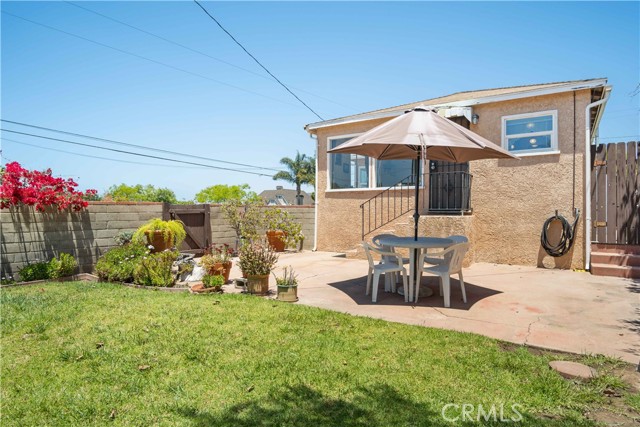 Nice sunny backyard has patio, grass yard and flower borders. This door leads into existing family room.