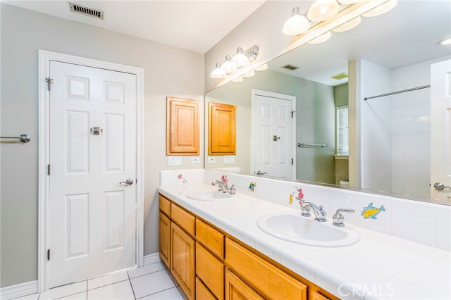 Jack 'n Jill bathroom with shower, tub, laundry shoot and double sinks