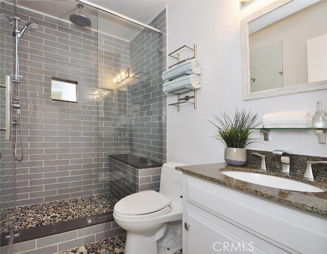 Glass tile, stone, quartz and granite touches. Grohe rainshowers and hand held heads + built in bench give it that 