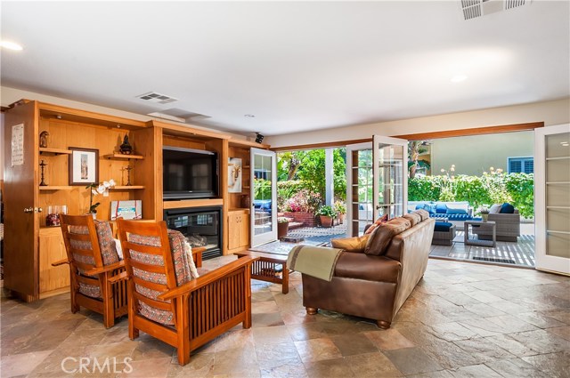 Family Room opens to a wonderful covered patio! The entertainment center is built around the gas fireplace. Great space for entertaining. There is a den or small office at the left corner of this room.
