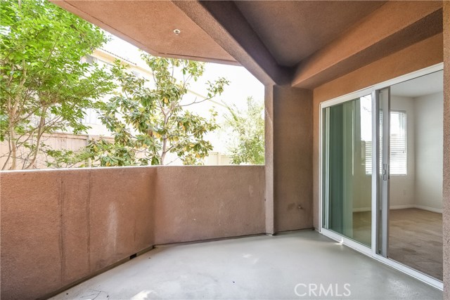 Over-sized balcony surrounded by trees.  Tucked away in corner on complex. (This photo without table & chairs.)