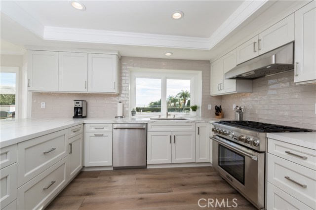 Stunning totally BRAND NEW kitchen with all the bells and whistles!  Gorgeous appliances and pretty light grey tile backsplash.  The wood floors are to die for! Kitchen window looks out to the yard and view beyond...