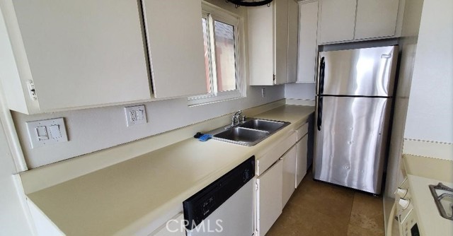 Lower Unit Kitchen with Travertine Floors and Dishwasher, Stove and Refrigerator