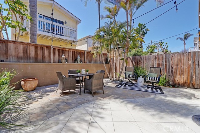 Larger than typical backyard features low maintenance patio and string lights on remote.