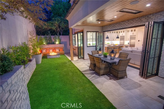 Private backyard, fire pit with seating, low maintenance artificial turf, covered patio with built-in heaters, sandblasted marble floor tiling, LaCantina door systems for the perfect indoor/outdoor experience, surround sound.