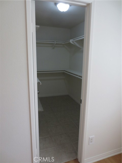 Master bedroom walk in closet has tile floors