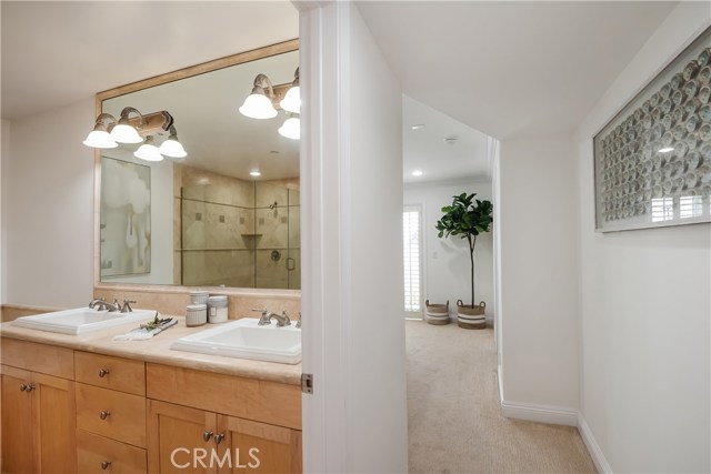 Primary en-suite bathroom with dual sinks and beautiful maple cabinetry.