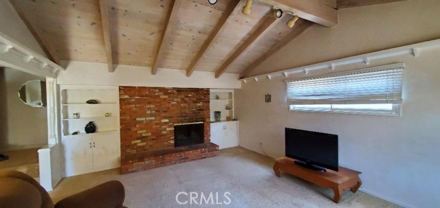 Living room with beautiful used brick fireplace and built-in bookshelves