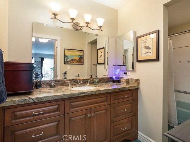 Master bath has been remodeled with exquisite granite countertop and beautiful vanity cabinet.  Bathtub with custom tile work is visible on right side of photo.