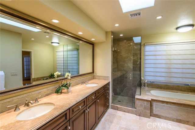 Large master bath with marble surfaces and walk-in closet.