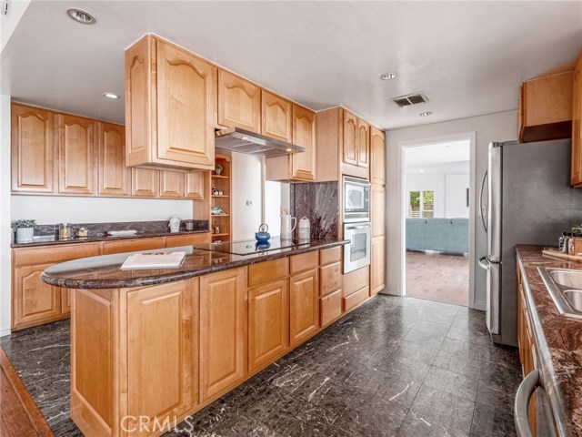 Kitchen View of Wall Storage, Cooktop, Oven, Microwave, and more storage