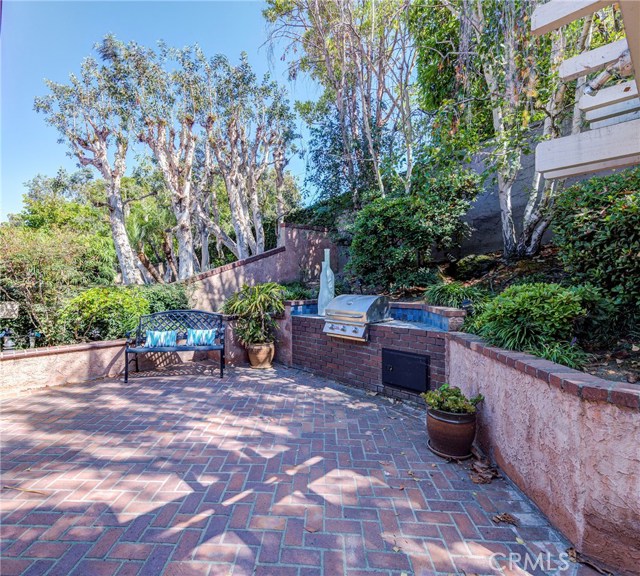 Brick Patio has raised Flower bed with trees