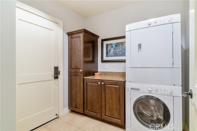 Laundry room with custom cabinetry and private owner's closet.