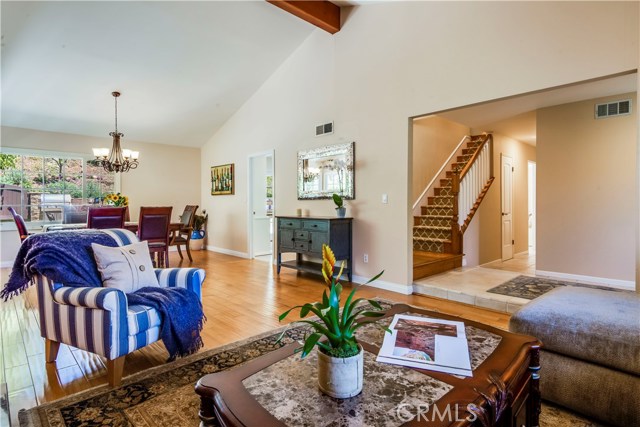 Living room with hardwood floors and high vaulted ceiling