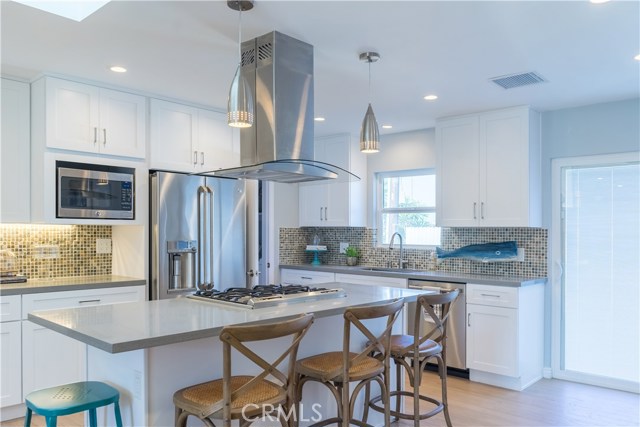 Shaker cabinetry and quartz counters showcase the entertaining island with plenty of seating.