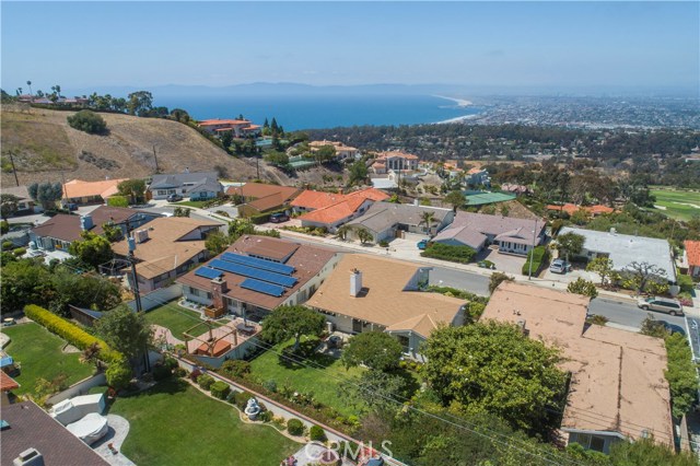 Aerial view -house is to the right of the home with solar panels on the roof.