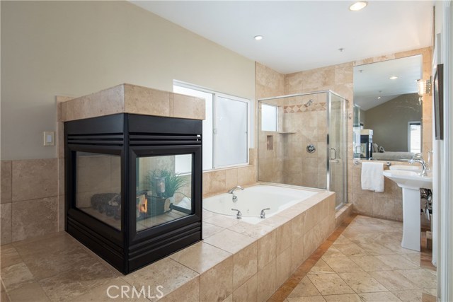 The master bathroom suite is highlighted by the elegant fireplace and features a large jetted tub, large shower, and customized walk-in closet.