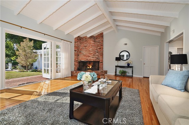 Living Room with Large Wood Burning Fireplace and French Doors to Yard