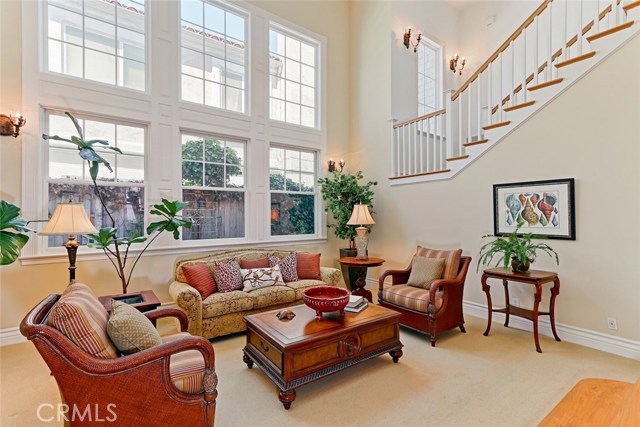 Two story ceiling and windows make this formal living room light, bright, and big.