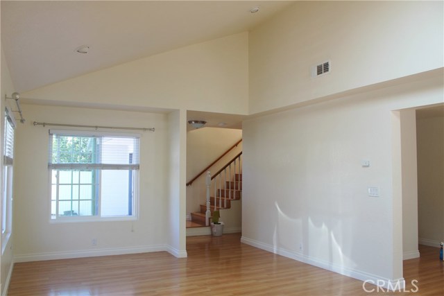 Spacious living room with gleaming hardwood floors and cathedral ceilings