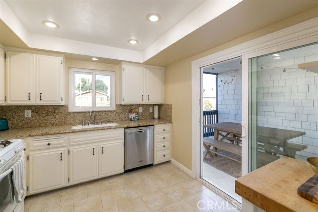 Updated kitchen with granite counter tops has access to the patio